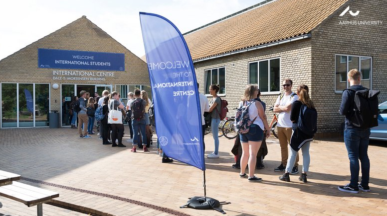 Male and female students standing in from of International students centre at Aarhus University, Denmark