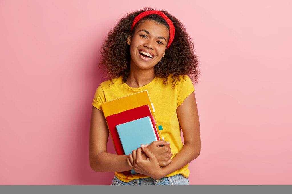 A smiling female student holding books